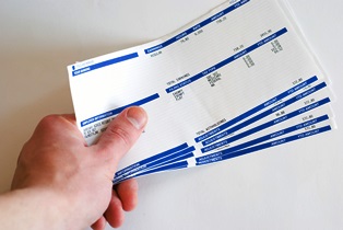 Male hand holding pay cheques checks in his hand on white background