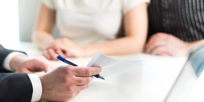 Couple having meeting with legal advisor, real estate agent, businessman or banker. Lawyer giving advice or consultant showing document or agreement to man and woman. Insurance or car leasing paper.